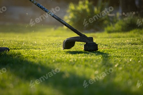 Preview: Garden worker with lawn mover. Garden works in spring.