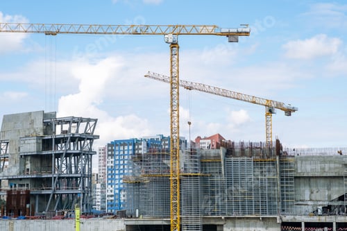 Preview: crane and a building under construction against a blue sky background