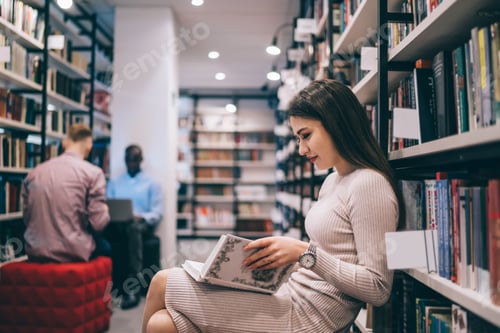 Preview: Positive lady resting in library and reading book