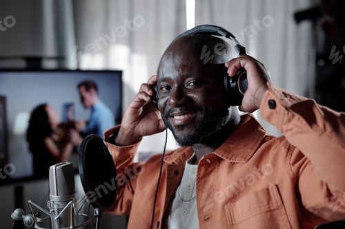 Preview: Smiling African American Man Wearing Headphones in Studio Setting