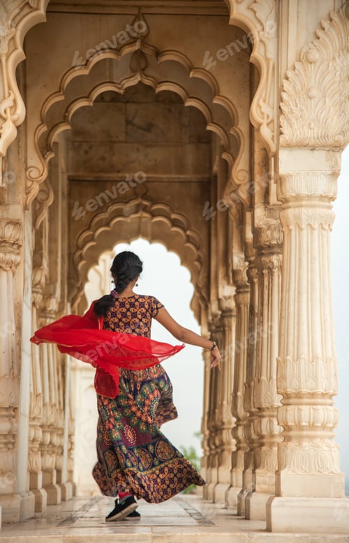 Preview: Young female tourist dancing between arches and Pillars.