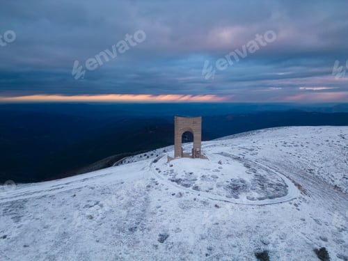 Preview: Beautiful aerial view of snow covered mountains and the Monument Arch of Liberty at the main ridge