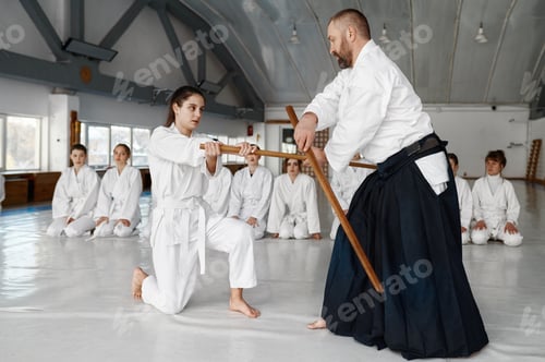 Preview: Sensei with young female student fighting with wooden sword
