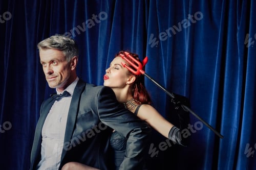 Preview: Male entertainer with burlesque dancer holding devil's fork