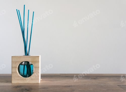 Preview: Closeup of a blue air freshener with reed sticks on a wooden table