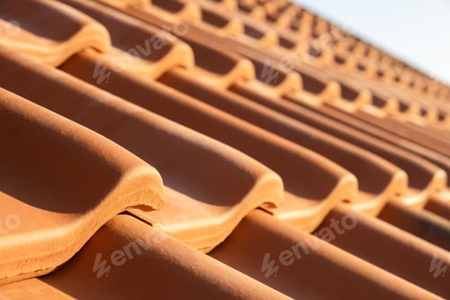 Preview: Overlapping rows of yellow ceramic roofing tiles covering residential building roof