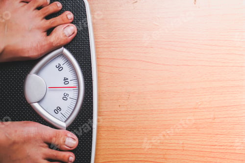 Preview: feet standing on a black scale weighing machine with a wooden base