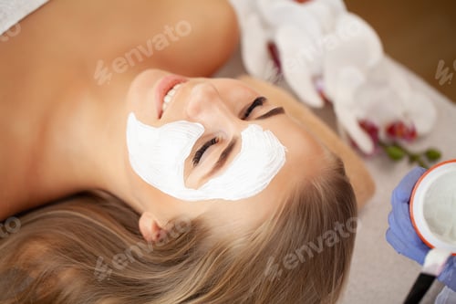 Preview: Woman getting spa face mask in beauty studio.