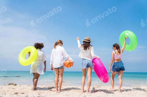 Preview: roup of teenage with floaty on the beach having fun in a sunny day