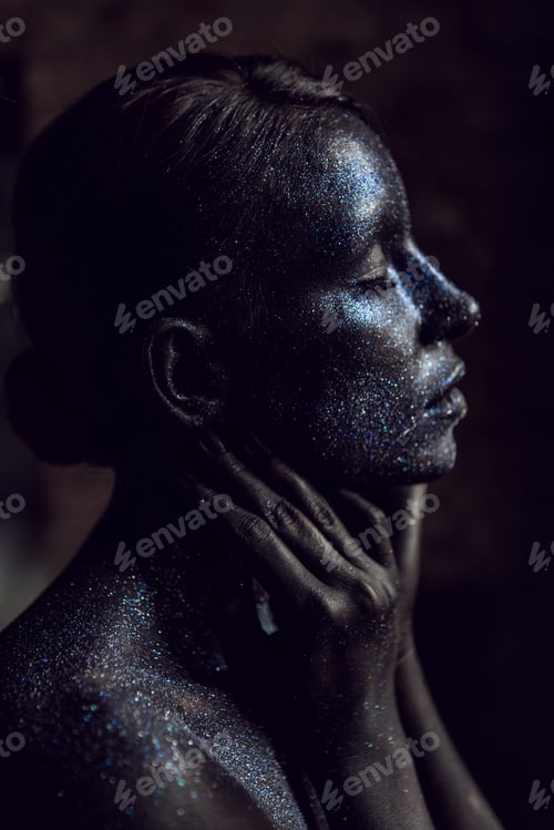 Preview: fashionable portrait of a woman in black paint with sequins on her face. closed eyes