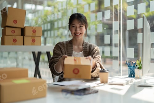 Preview: Young Asian Woman holding parcel box for delivery by logistic service. small business entrepreneur