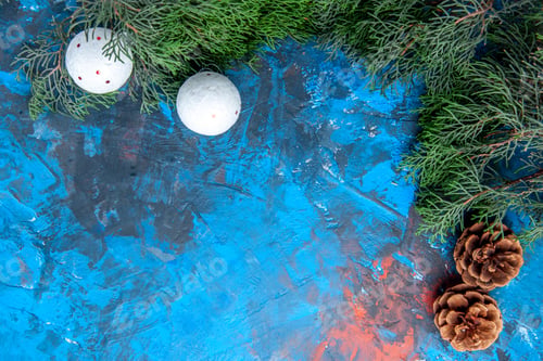 Preview: bottom view pine tree branches pinecones white xmas tree toys on blue-red background with free