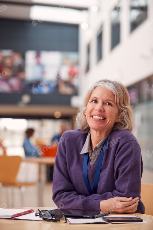 Preview: Portrait Of Mature Female Teacher Or Student With Digital Tablet Working At Table In College Hall