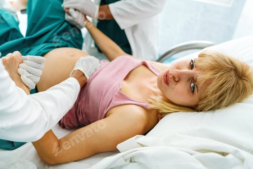 Preview: Woman giving birth in hospital with medical doctor team