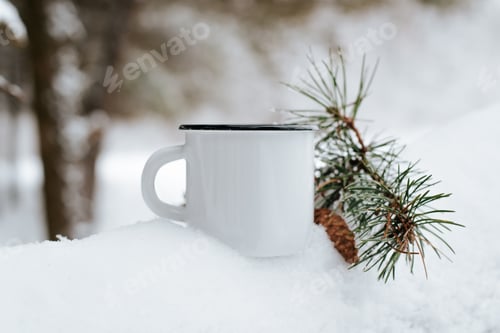 Preview: White camping mug mockup in pine forest. Close-up of an iron mug with handle standing