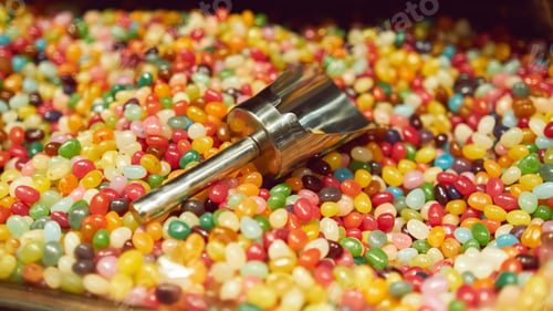 Preview: Mixed multi-colored jelly beans Mixed multi-colored jelly beans and a metal scoop in a candy store.
