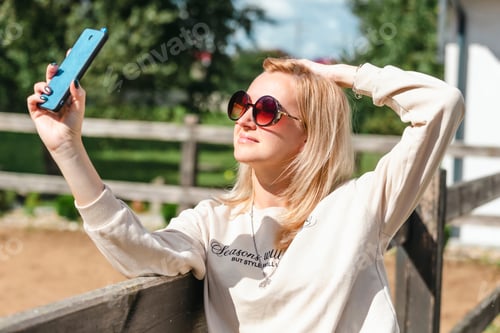 Preview: Woman Taking Selfie Outside on Sunny Day
