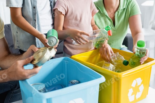 Preview: Cropped view of family and children sorting garbage in boxes with recycle sign