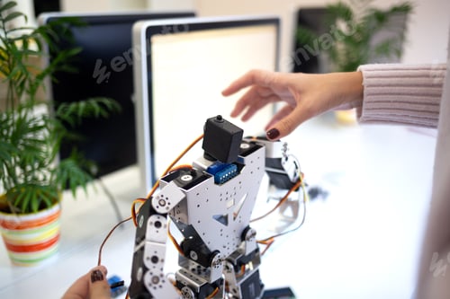 Preview: shooting close-up. woman designs a large modern robot