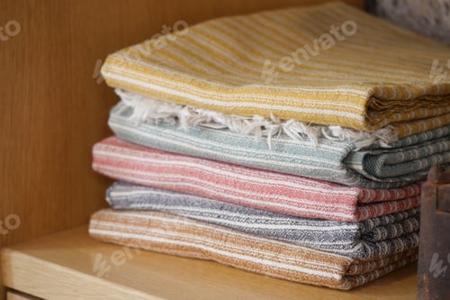 Preview: Colorful woven textiles stacked on a wooden shelf