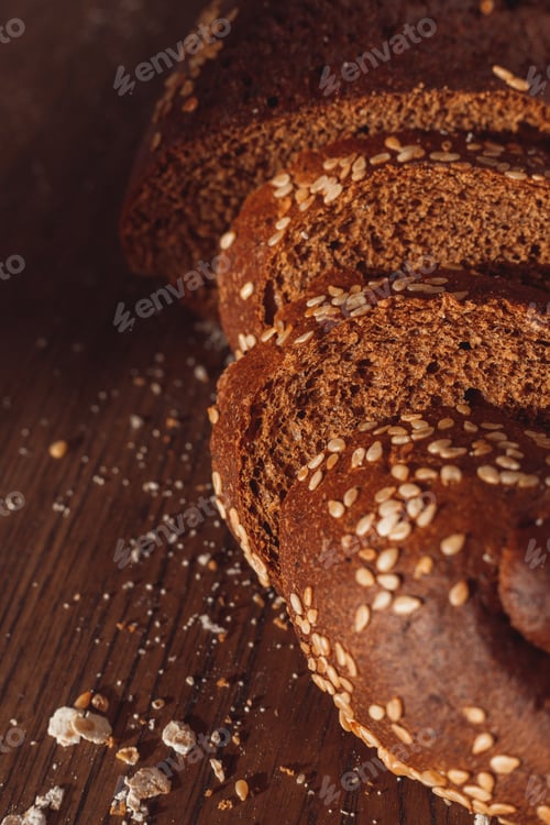 Preview: Sliced rye bread on cutting board. Whole grain rye bread with seeds