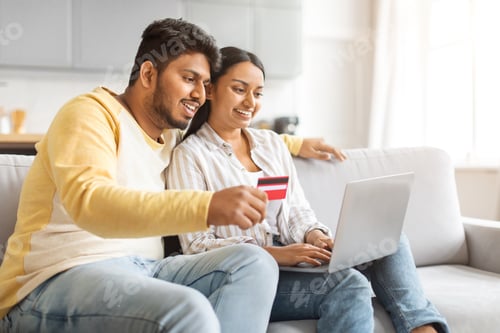 Preview: Indian Man and Woman Sitting on Couch, Shopping With Laptop