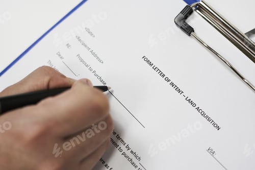 Preview: Closeup of a person signing a Form letter of intent for land acquisition