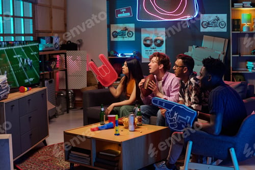 Preview: Diverse Young Adults Watching Football Game and Cheering with Foam Hands