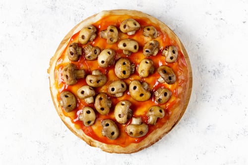 Preview: Homemade pizza with tomato sauce and mushrooms in the form of skulls. Concept for Halloween