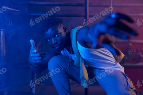 Preview: Young cool guy rapper posing for camera in neon light