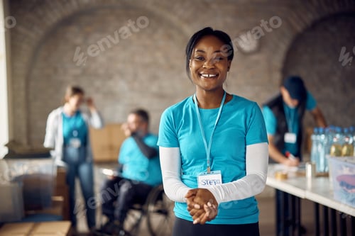 Preview: Young happy black woman working as volunteer at community center.