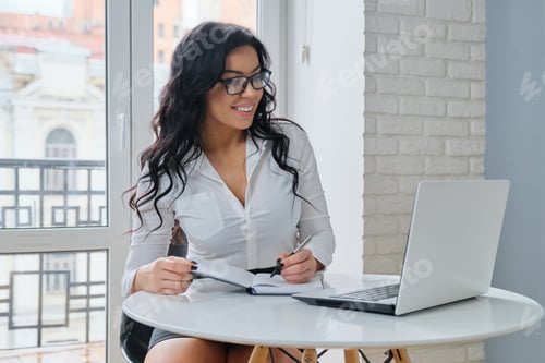 Preview: Beautiful businesswoman beauty manager working in the office at laptop