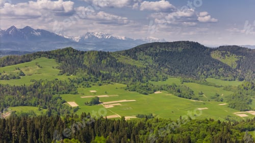 Preview: Aerial drone view over green hills of Pieniny National Park and snowy Tatra Mountains