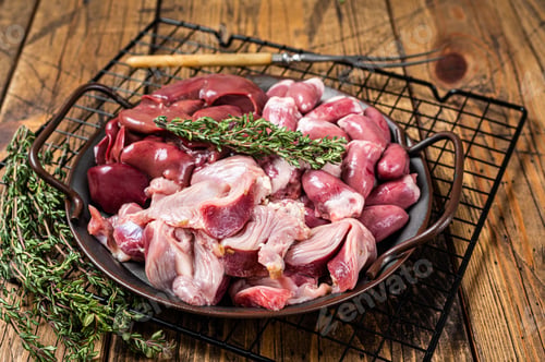 Preview: Raw bird giblets meat set, chicken offals, liver, hearts, gizzards Stomach. Wooden background. Top