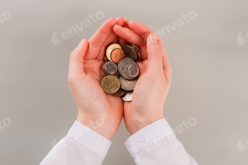 Preview: Female hands with heap of coins.