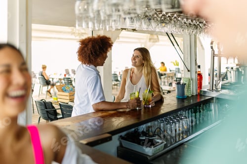Preview: Diverse young people enjoying a mojito drink while hanging out at beach bar