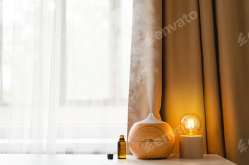 Preview: Aromatherapy concept. Aroma oil diffuser on the table against the window.