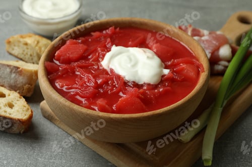 Preview: Concept of tasty eating with borscht and ingredients on gray table
