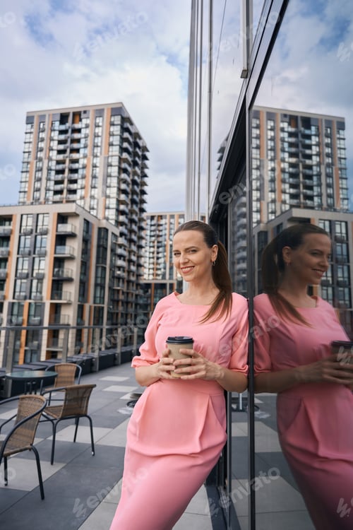 Preview: Woman manager in a beautiful dress stands on huge terrace