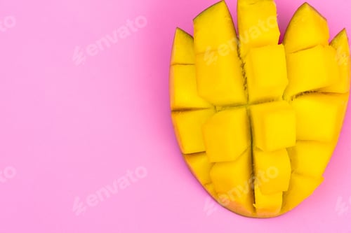 Preview: Fresh ripe mango on a pink background. Half a sliced mango on a pink background