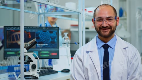 Preview: Portrait of scientist man smiling at camera sitting in modern laboratory