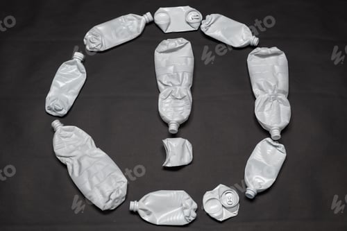 Preview: Exclamation mark in the circle is laid out of plastic and tin cans on a black background. Concept