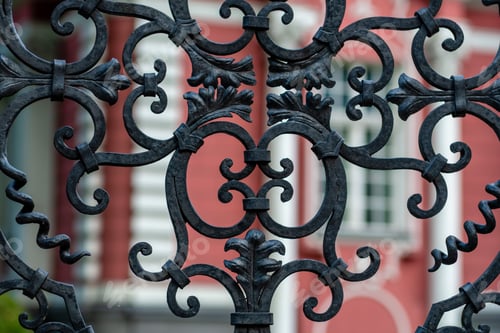 Preview: Ornate Wrought Ironwork Against a Red Building Facade