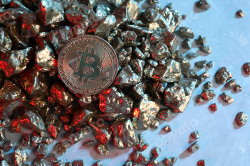 Preview: Bitcoin and gold nuggets on table in red light, flat lay