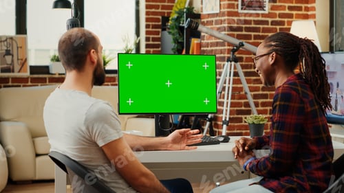 Preview: Diverse team of colleagues looking at computer with greenscreen