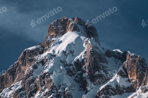 Preview: Low angle shot of a part of a mountain range and a blue sky in winter