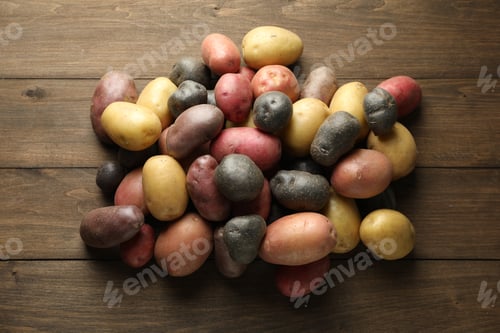 Preview: Different types of potatoes on wooden table, flat lay