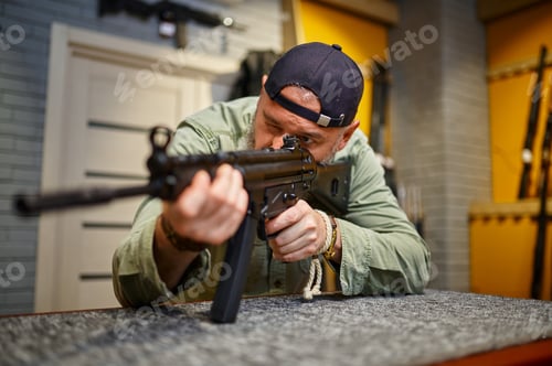 Preview: Bearded man checks the rifle scope in gun store