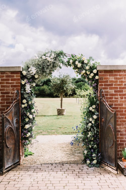 Preview: A door in a wall, and a white rose arch in a garden, with a view to a sundial.