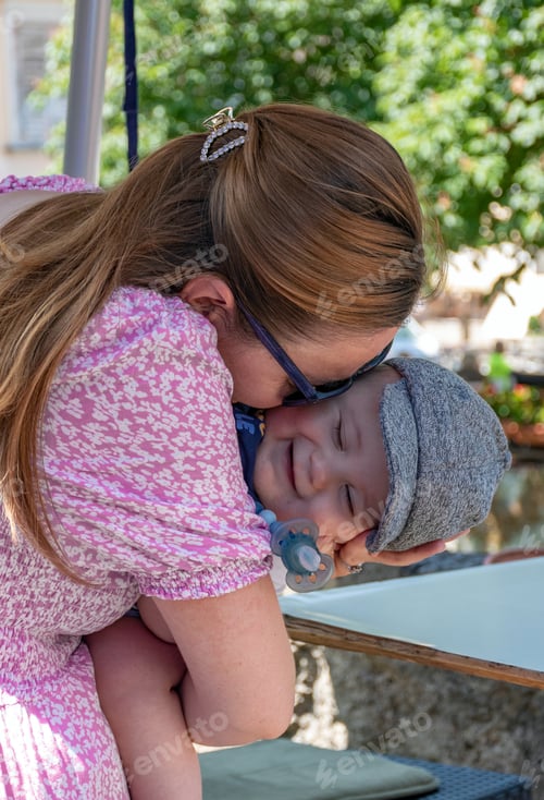 Preview: Mother holding and cuddling her baby son